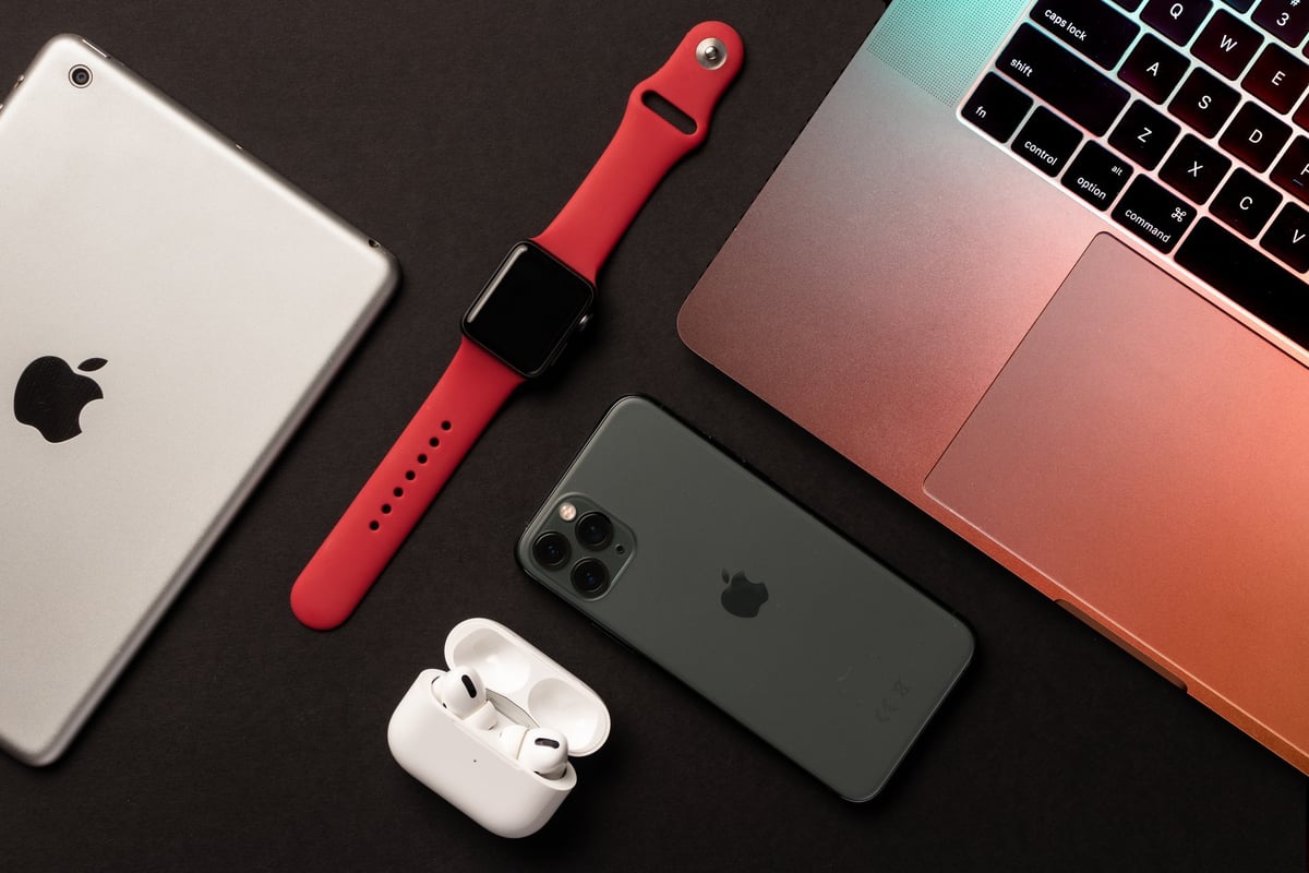 Apple products flat lay on dark background