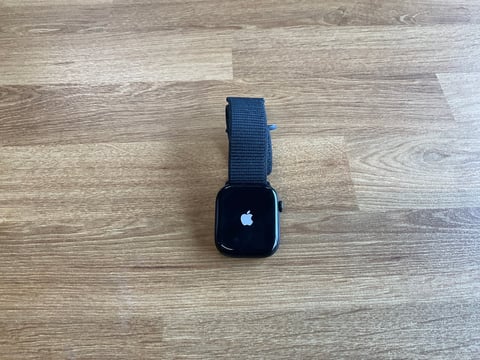 Apple Watch with dark blue woven band on wooden surface