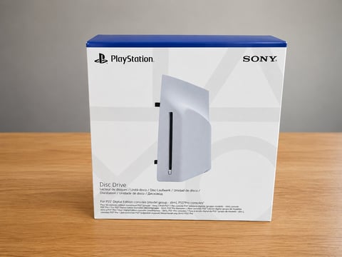 PlayStation 5 disc drive edition retail box on wooden surface with Sony and PlayStation branding visible