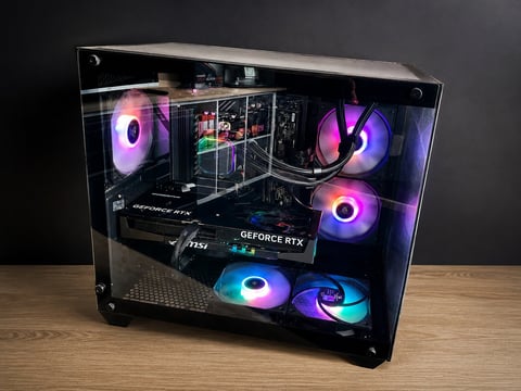 Custom gaming PC case with RGB lighting featuring multiple colorful fans, graphics card, and internal components visible through tempered glass