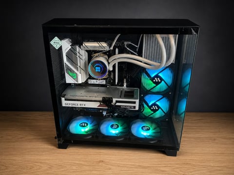 Computer tower case with blue LED cooling fans, internal components, and cable management on wooden surface
